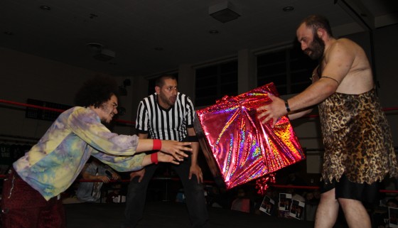 Jacob Hendrix giving Grop the Caveman a "gift" during their match